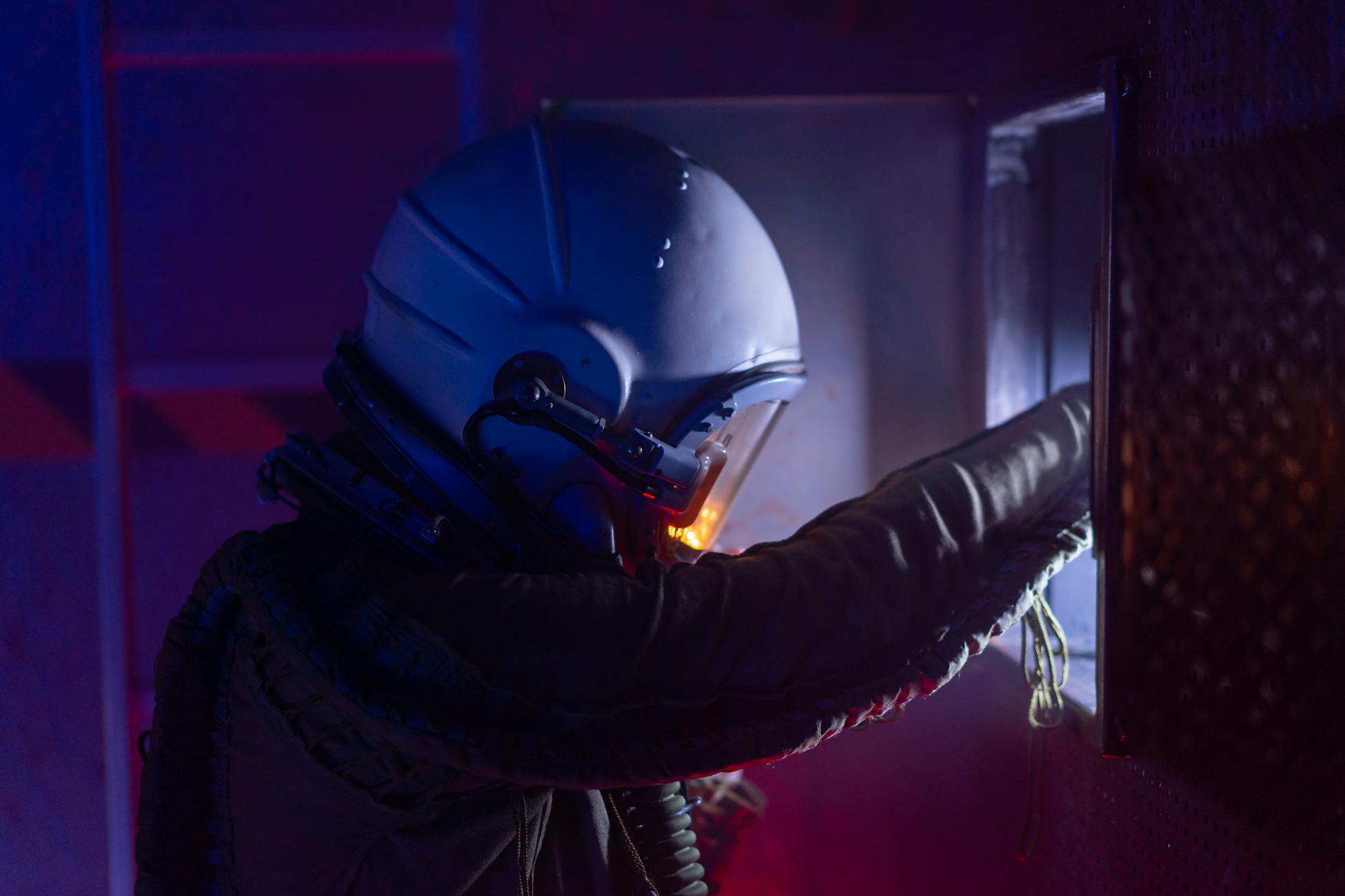 Astronaut in a futuristic space suit exploring a spacecraft with vivid lighting.