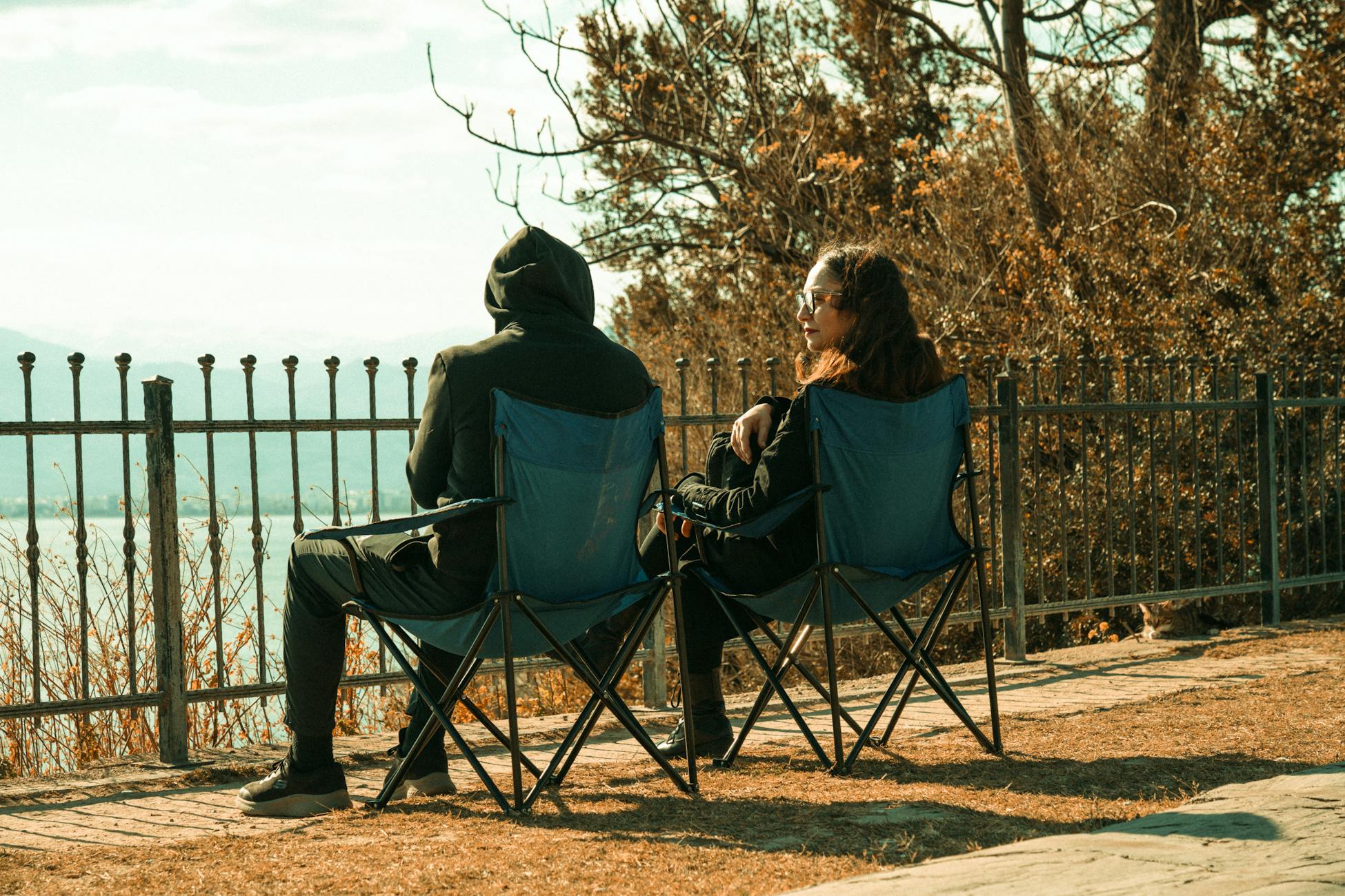 A couple sitting on lawn chairs, enjoying a scenic view in Antalya, Türkiye.
