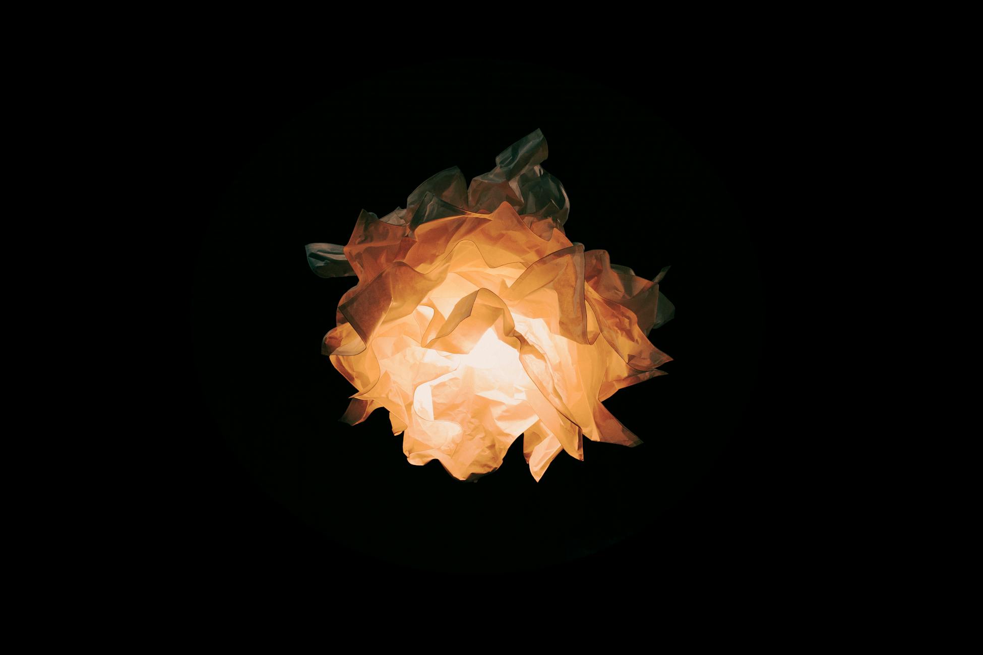 An artistic light fixture with warm glow set against a dark background, offering a dramatic and creative visual.
