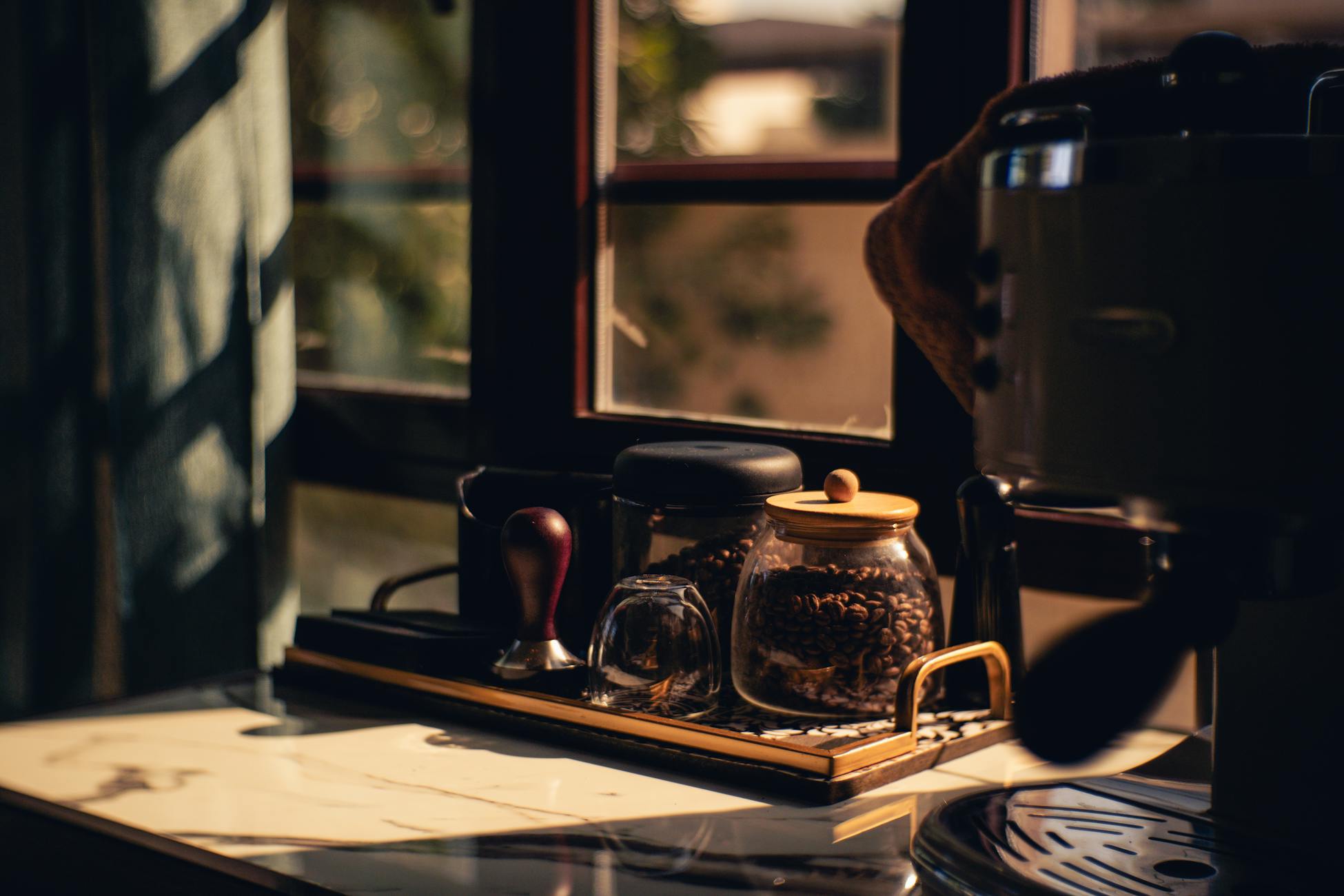Stylish coffee corner with equipment and beans in warm sunlight by a window. Perfect for cozy mornings.