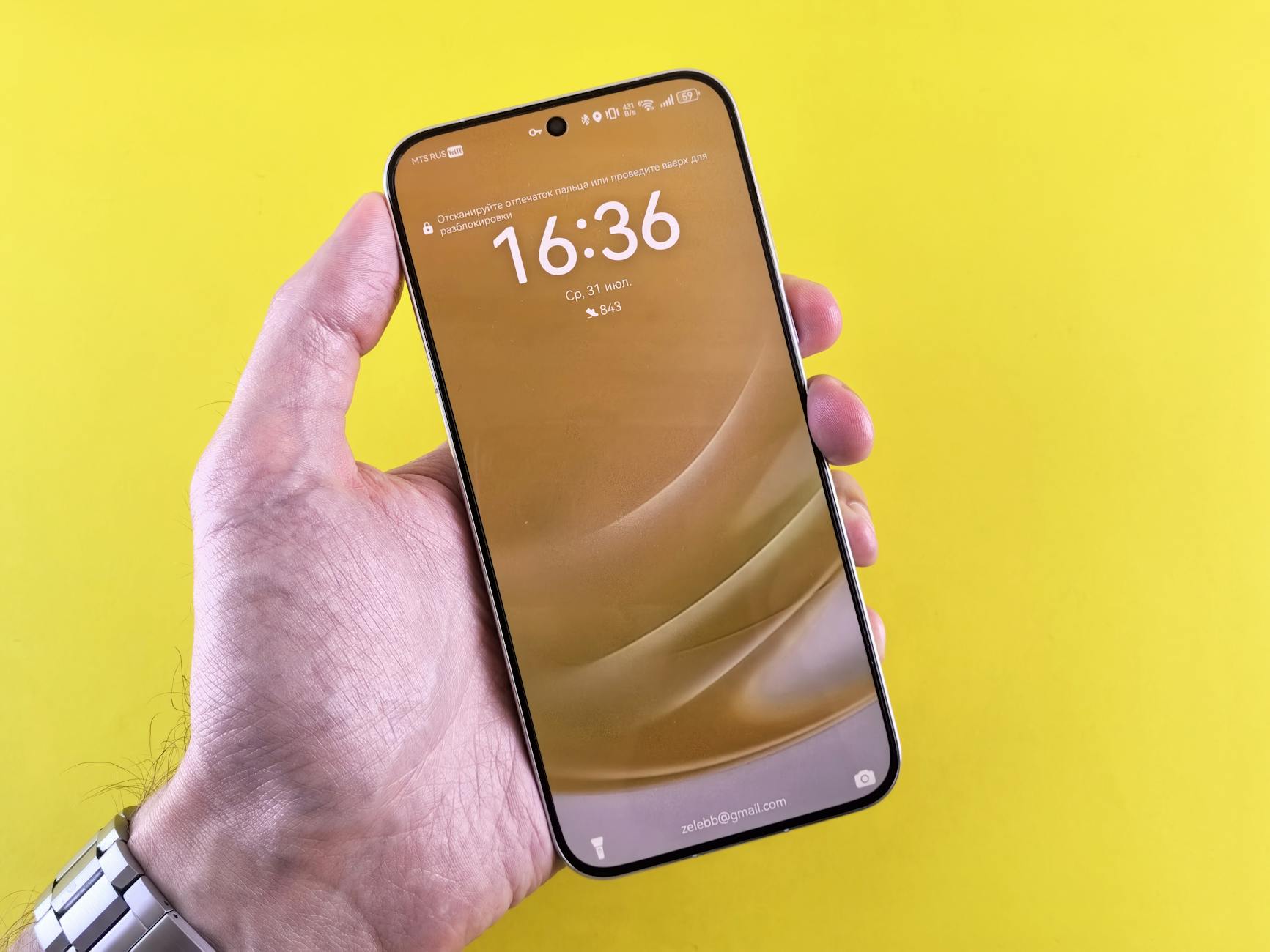 Close-up of a hand holding a modern smartphone with yellow background. Ideal for technology and lifestyle concepts.