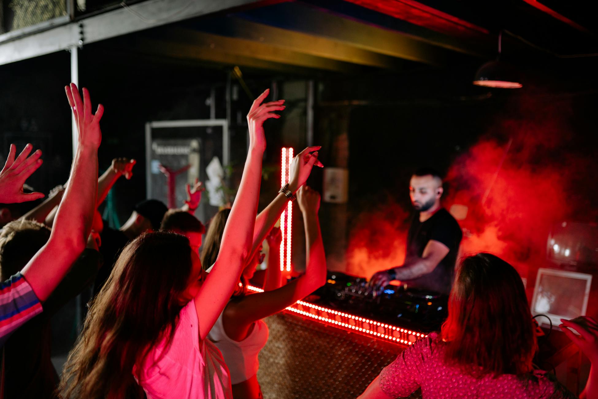 Vibrant nightclub atmosphere with a DJ playing music and crowd enjoying the night.