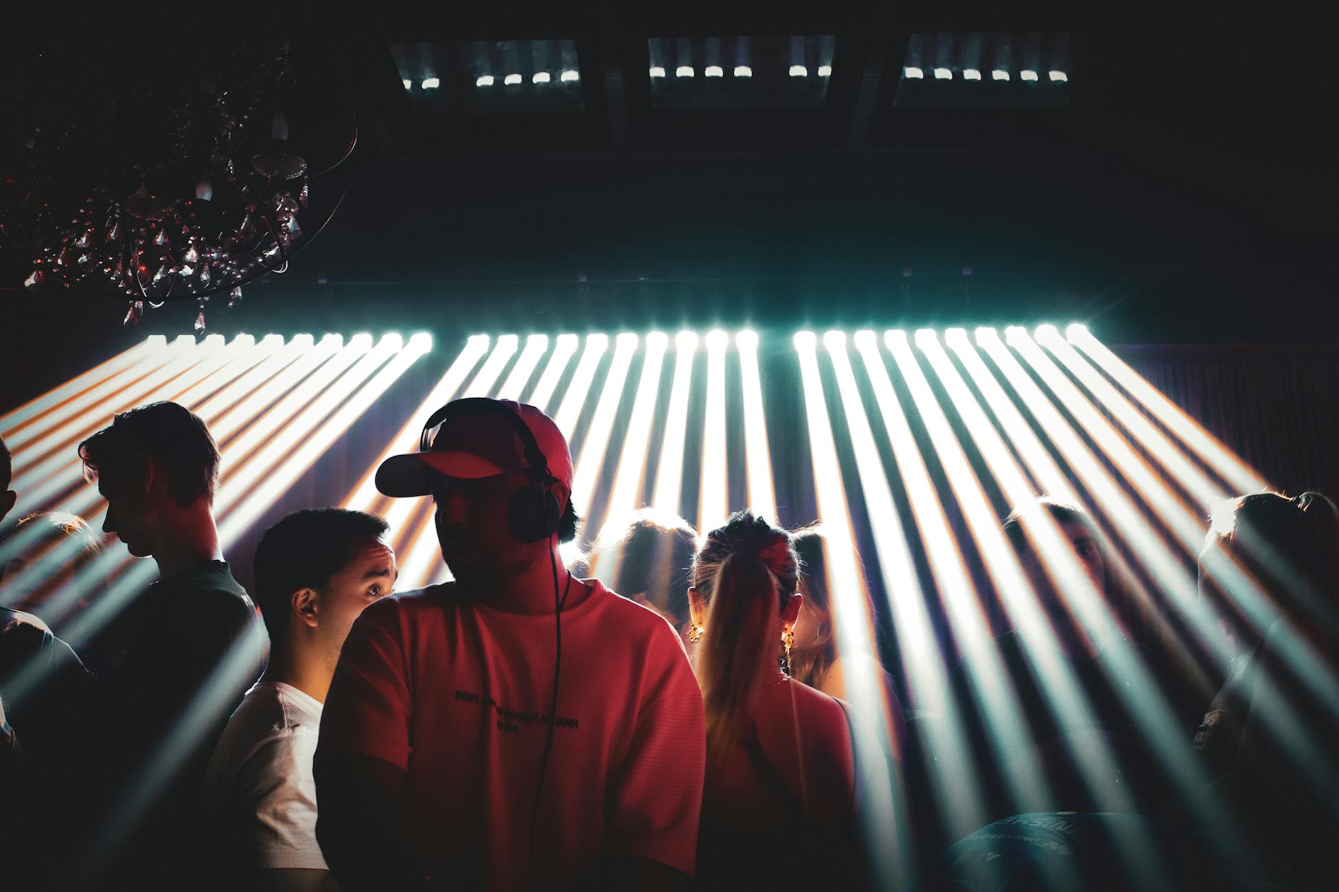 Energetic nightclub setting with people enjoying music and vibrant spotlight effects.