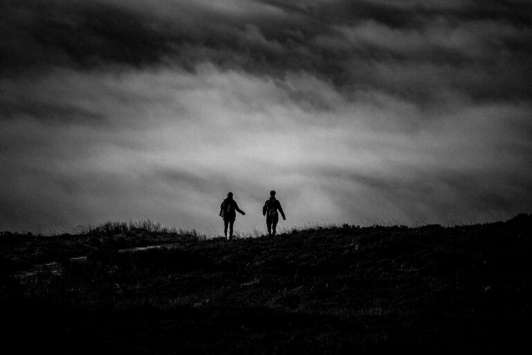 Silhouette of two hikers on a dramatic landscape in Northern Ireland.