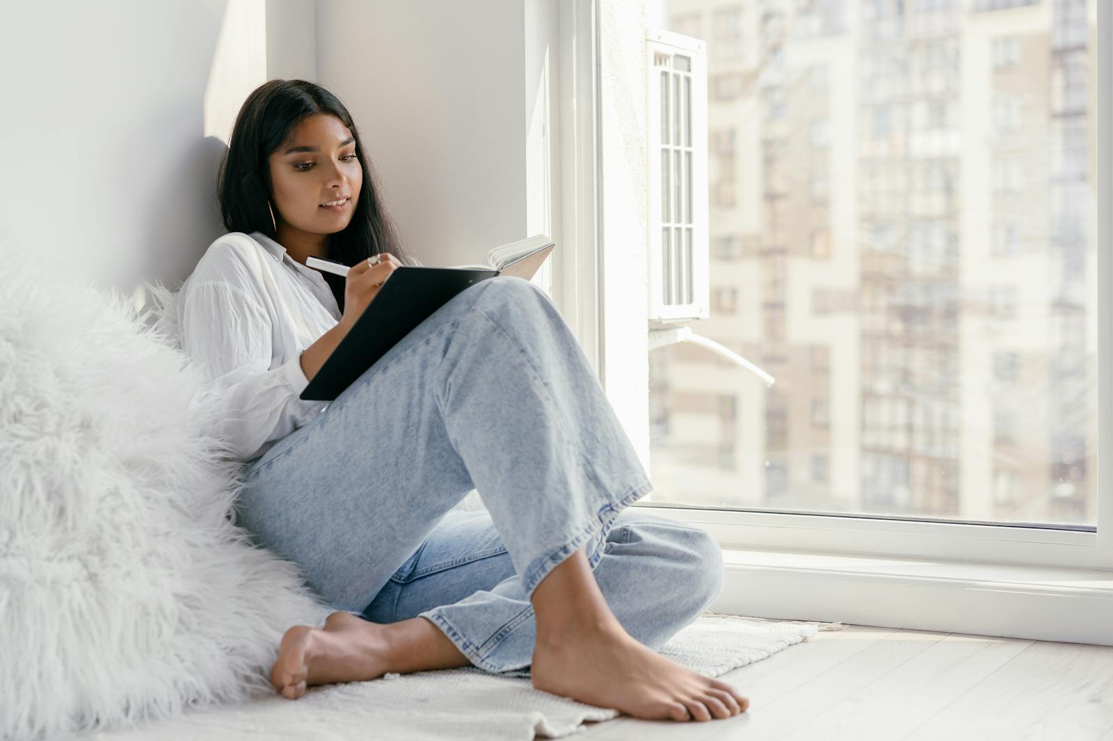 woman writing journal window