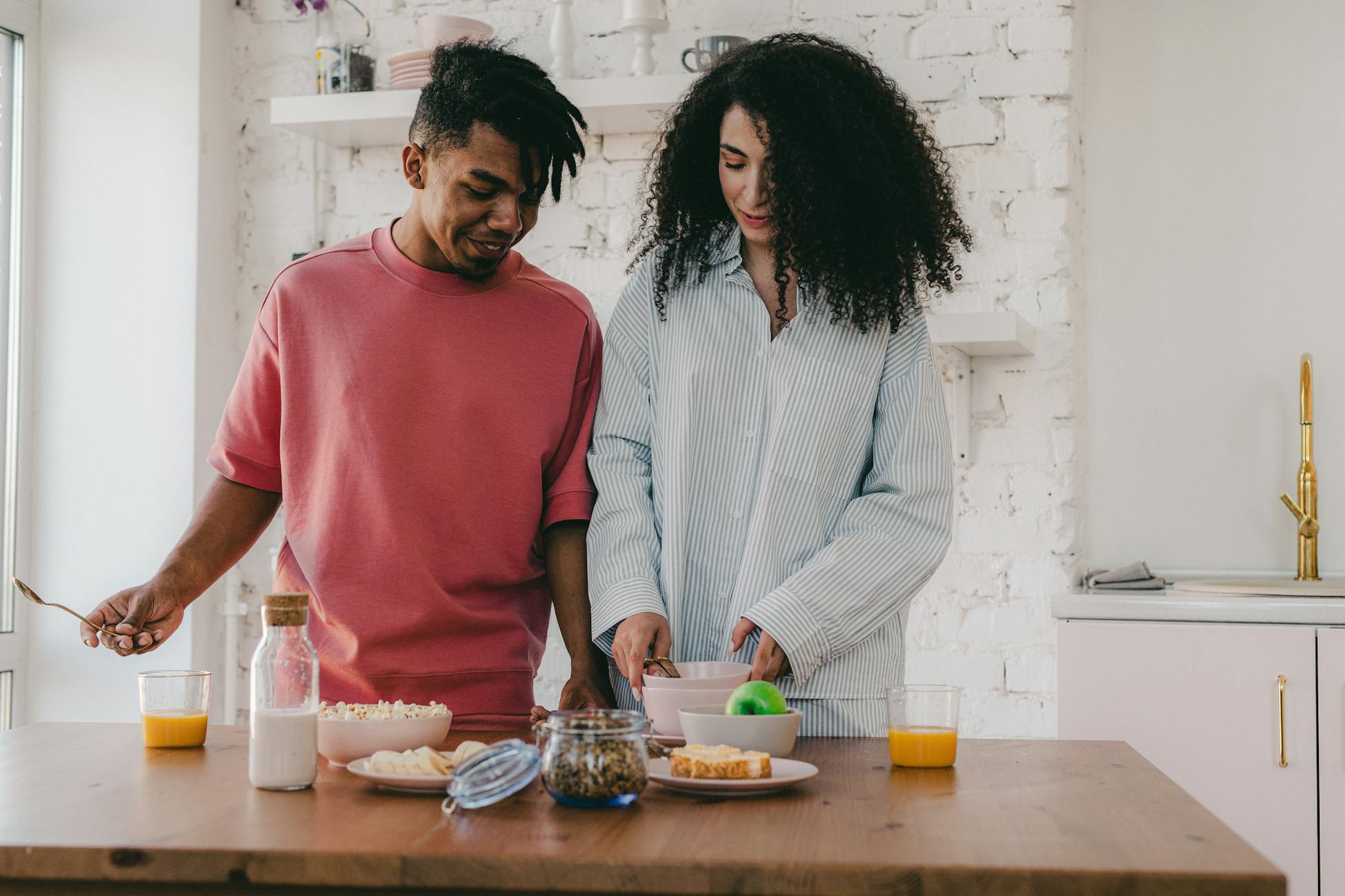 A happy interracial couple preparing breakfast in a cozy kitchen setting.