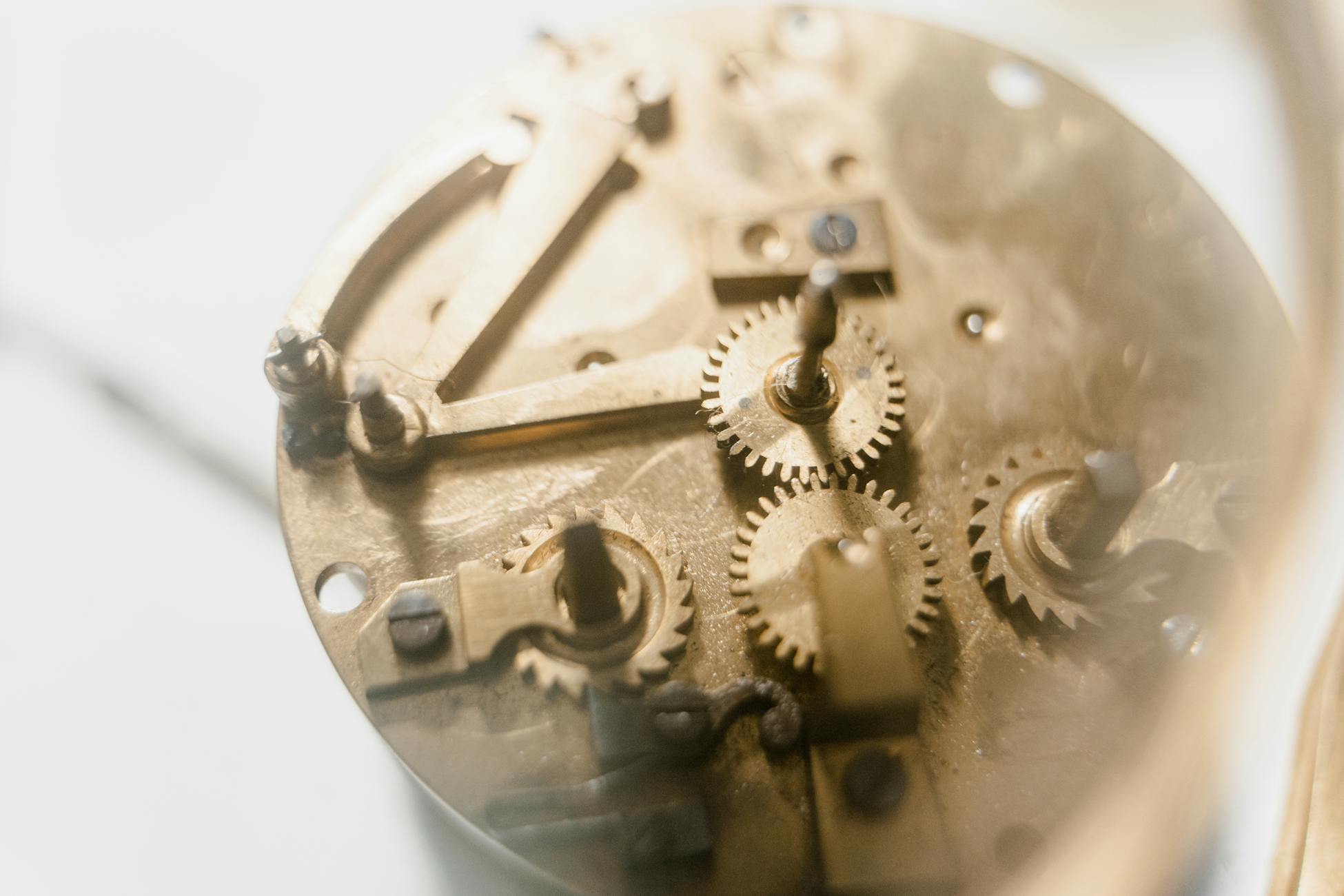 Detailed view of clockwork mechanism showing brass gears and components in soft focus.