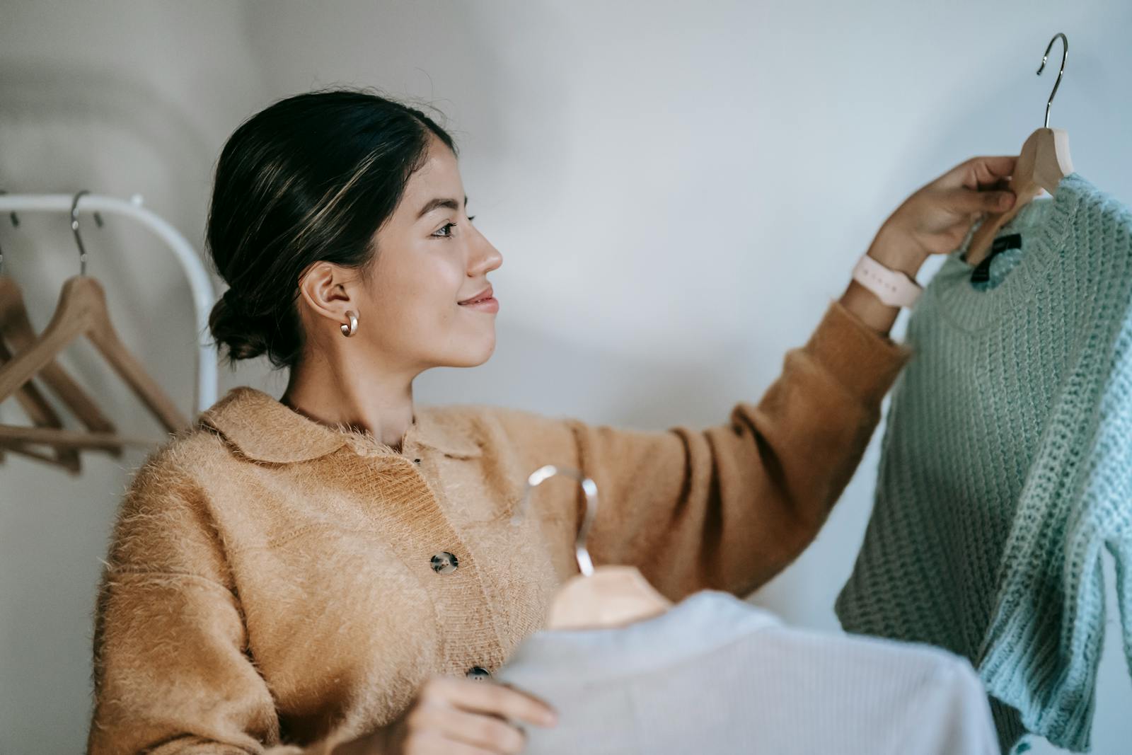 woman holding two sweaters