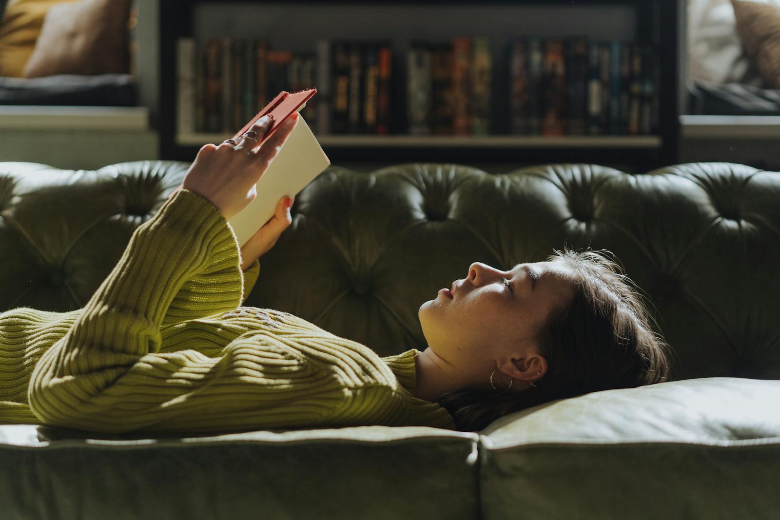 woman reading book couch