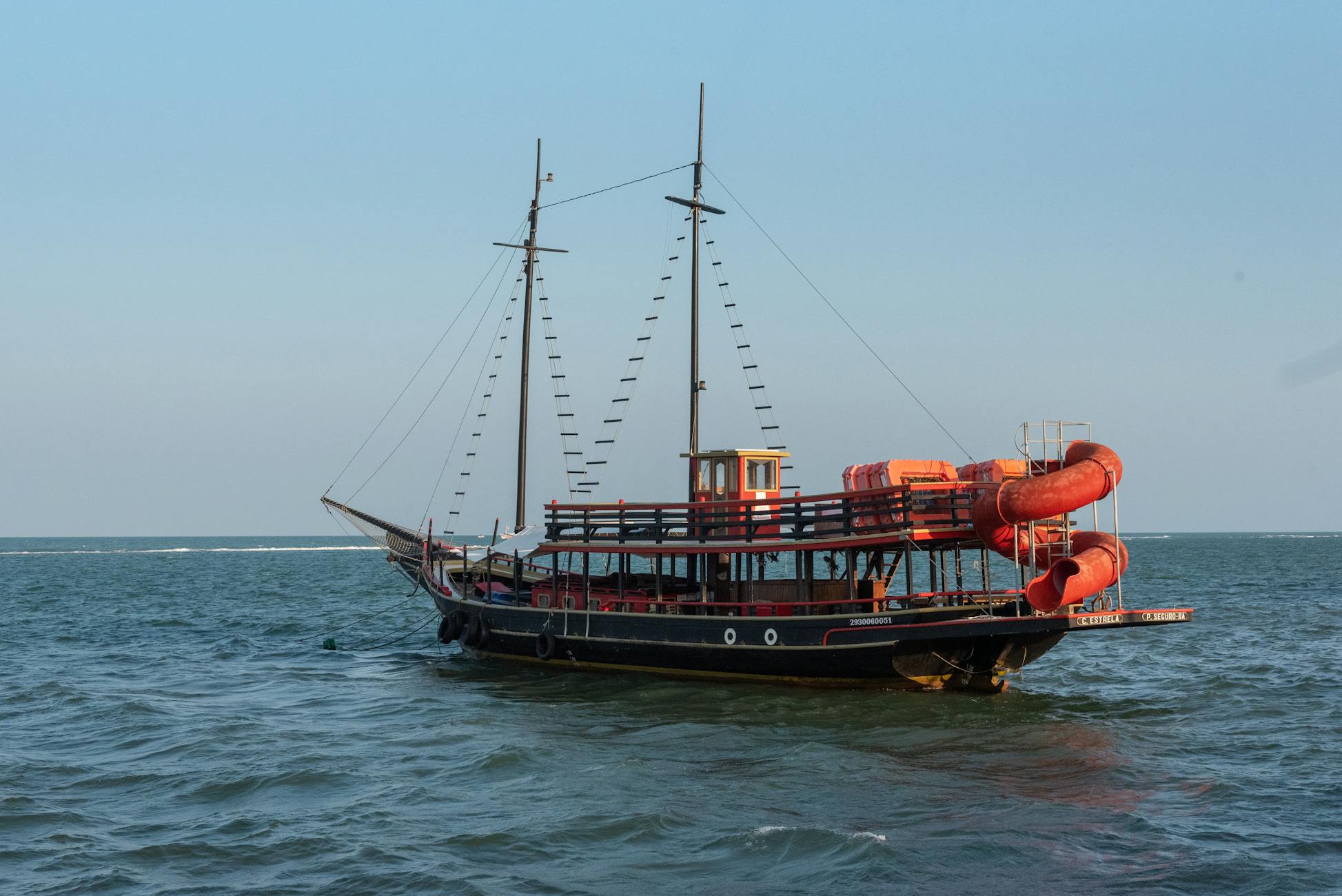 Pirate-style boat sailing in the serene waters of Porto Seguro, Brazil.