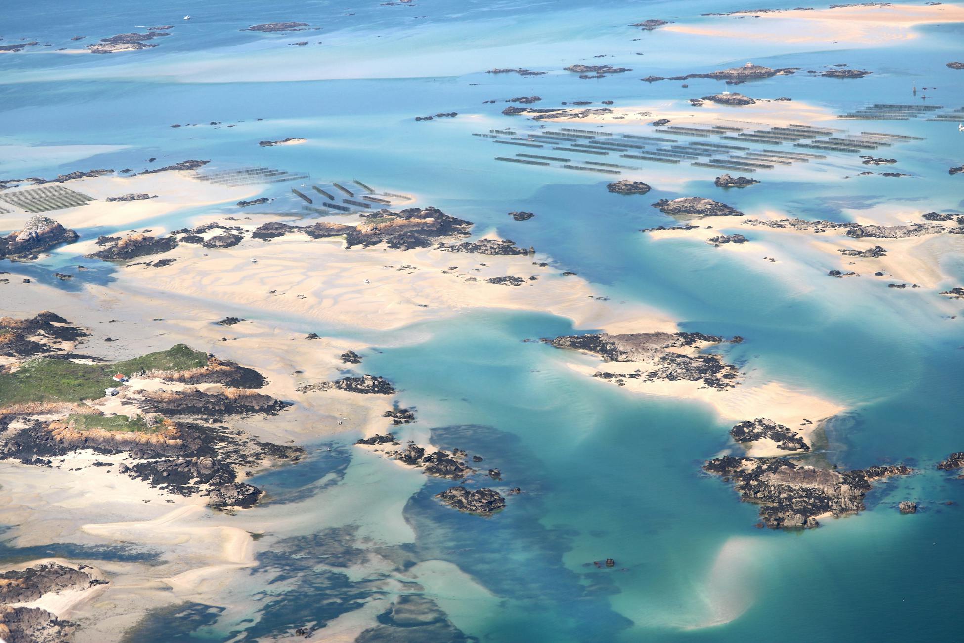 Stunning aerial photograph showcasing the sandy tidal formations along the coast of Normandy, France.