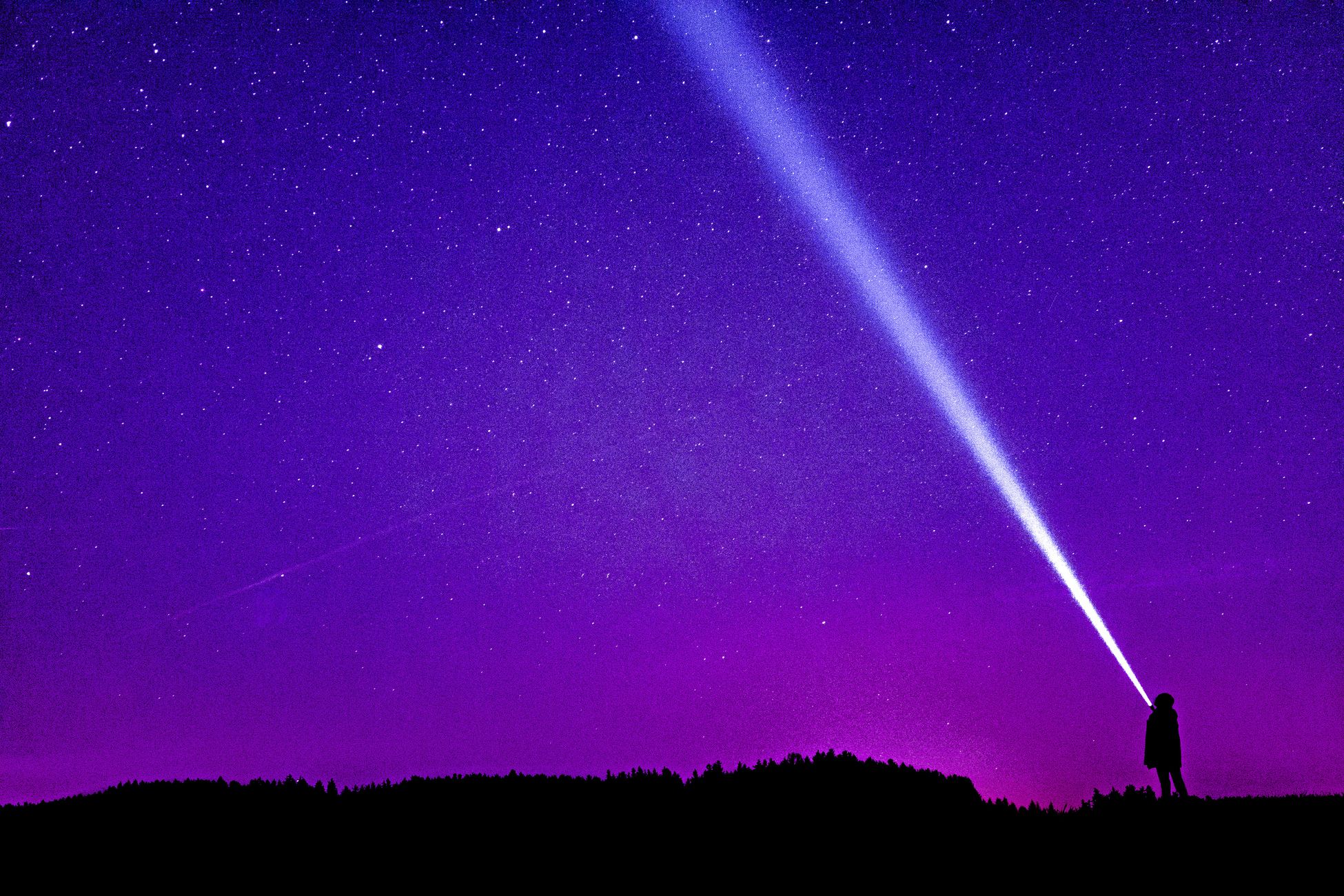 Silhouette of a person shining a flashlight under a starry violet night sky, creating a dramatic scene.