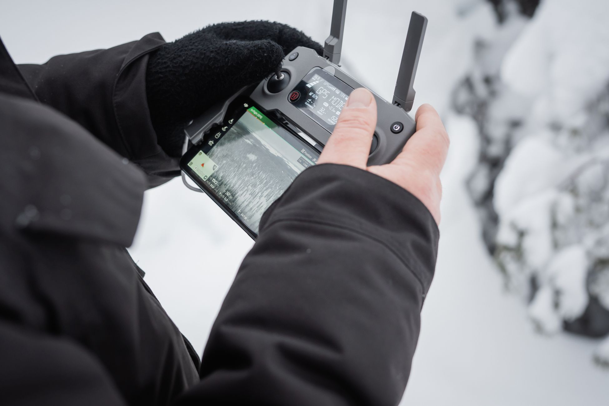Close-up of hands operating a drone controller in snowy Finland. Winter technology adventure.