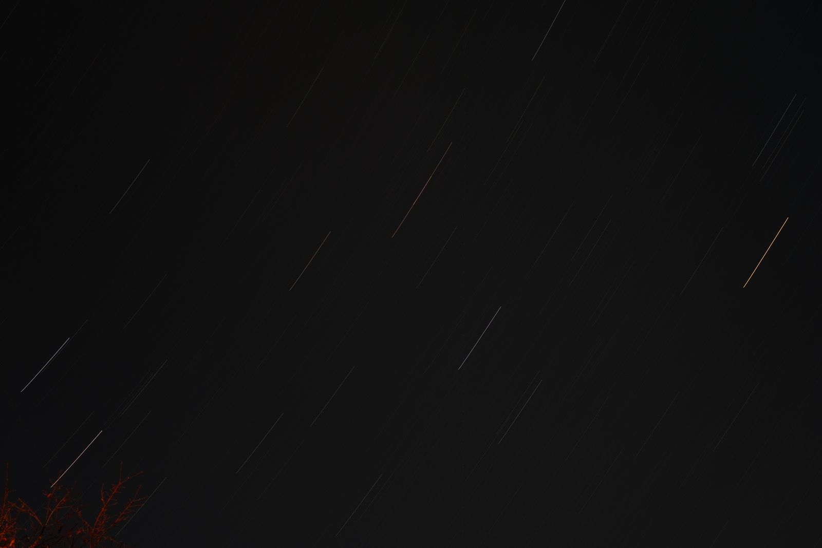 satellite trails crossing a dark astronomical sky
