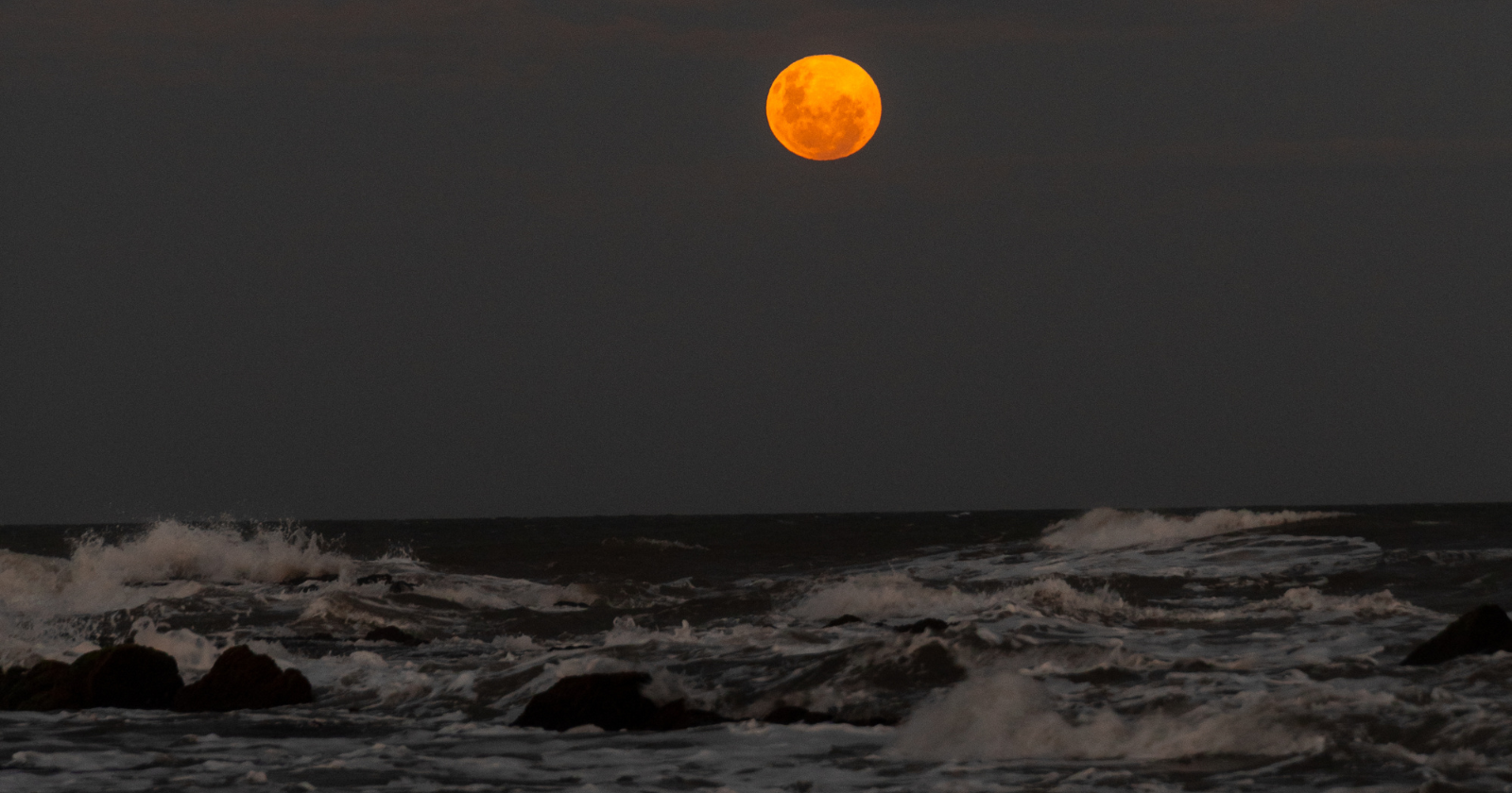 The sun is 27 million times heavier than the moon, yet its pull on our tides is only 46 per cent as strong — because tides answer to the difference in gravity across a planet, and distance kills that difference fast