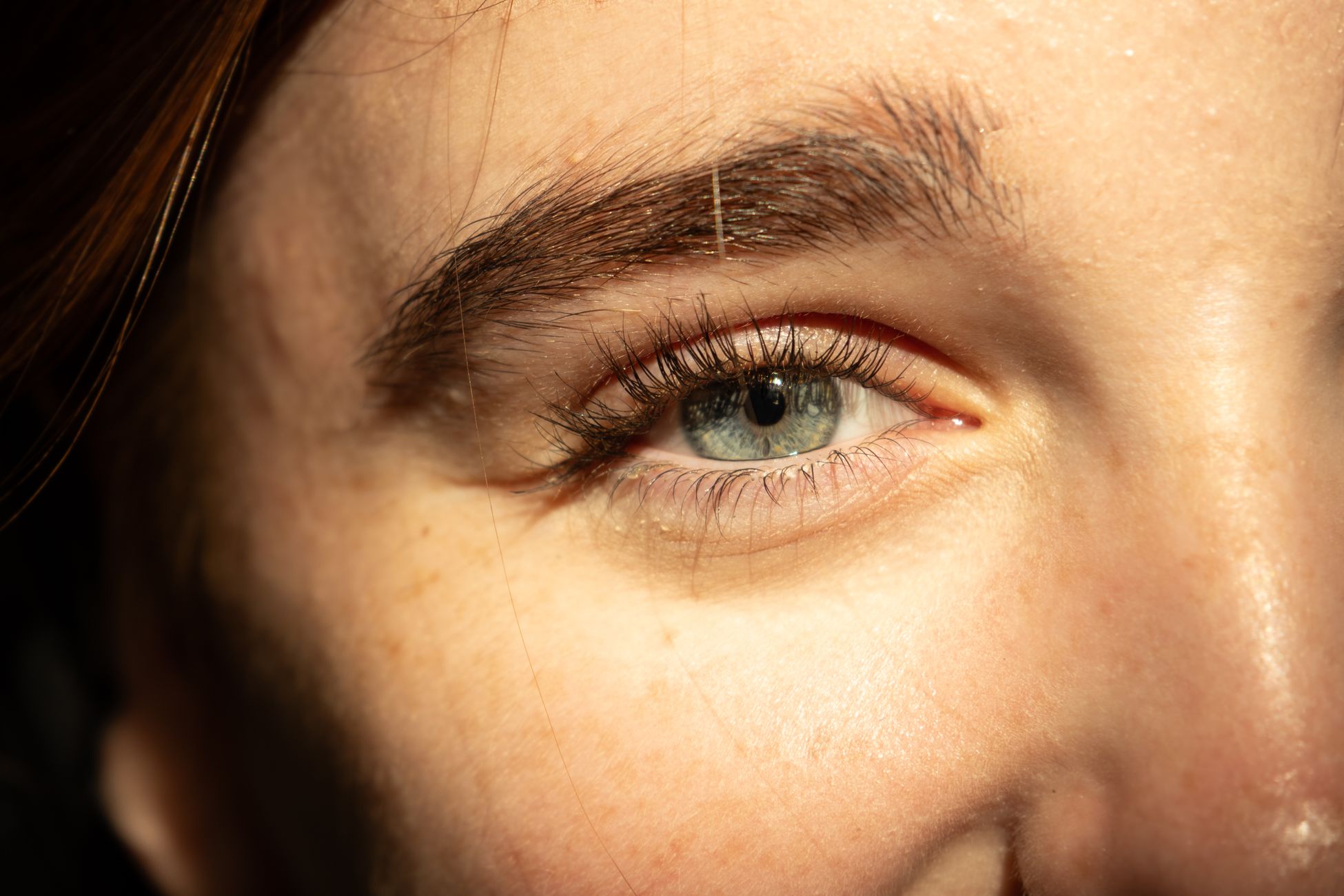 Detailed close-up of a human eye with natural lighting highlighting the iris and eyelashes.