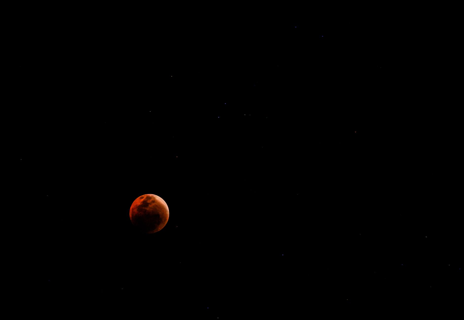 Captivating image of a blood moon with scattered stars in the night sky.