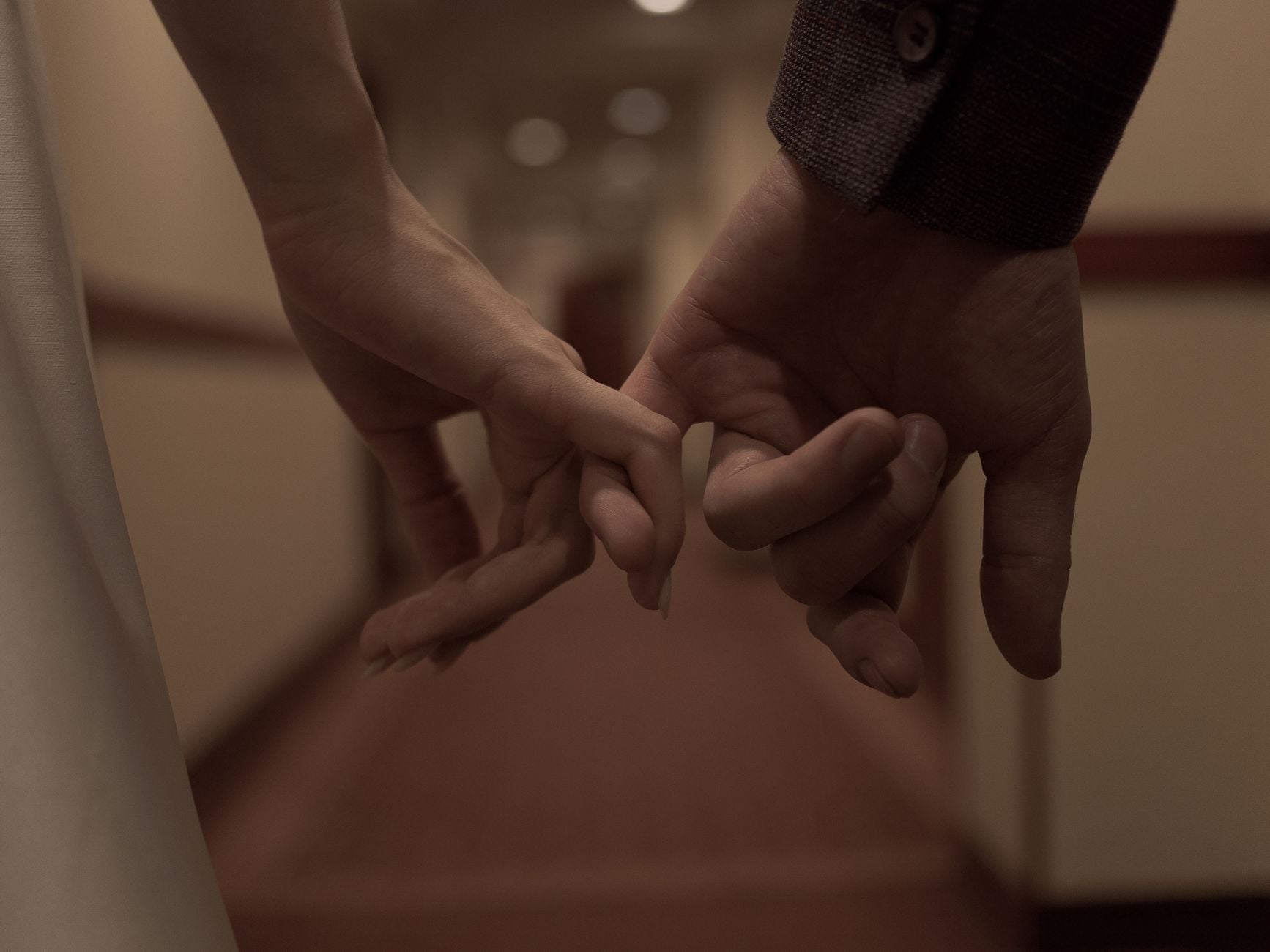 Tender close-up of two hands holding each other, symbolizing love and connection.