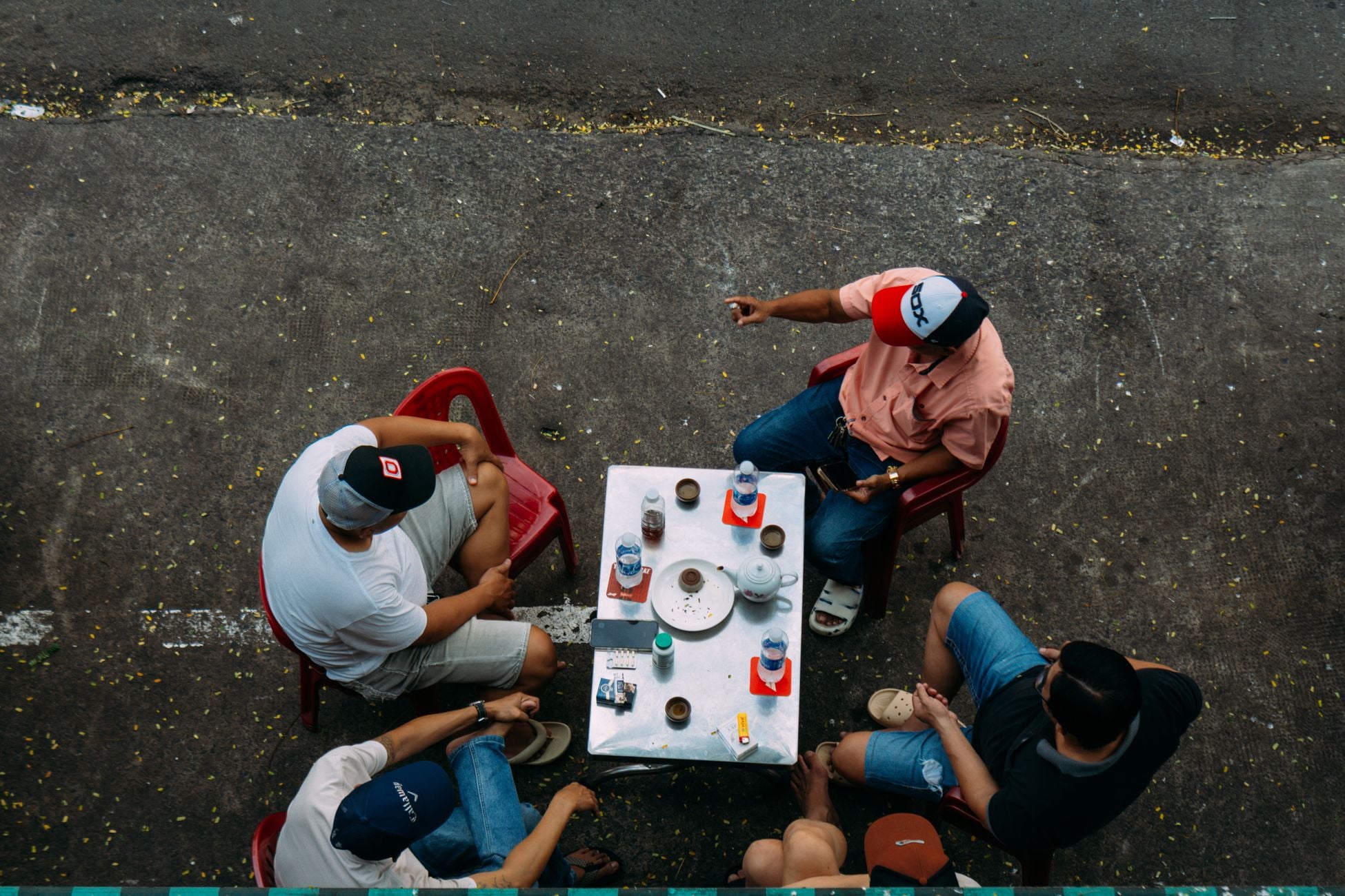 Overhead view of friends enjoying a casual outdoor coffee gathering.