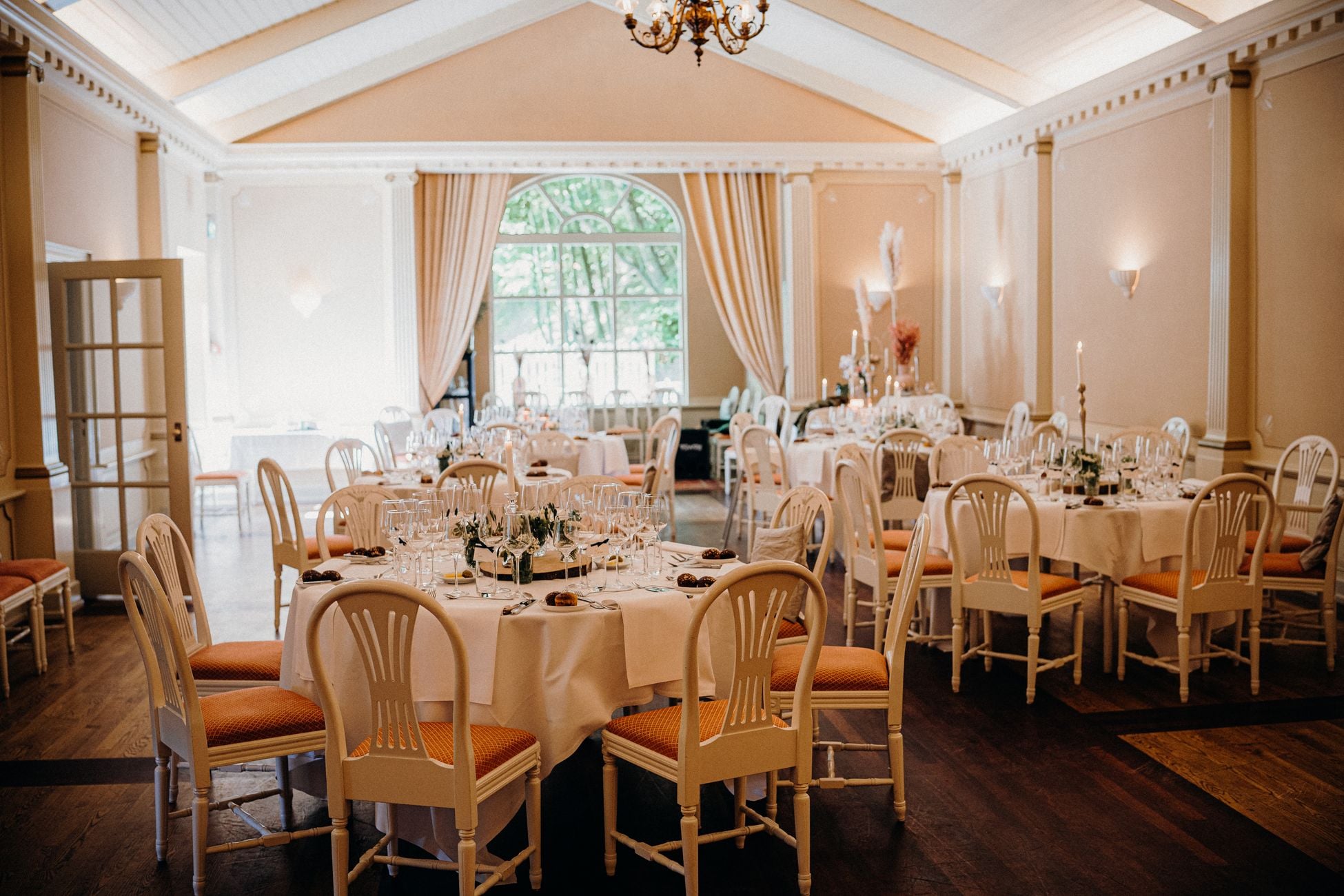 Beautifully arranged dining room perfect for weddings or receptions, featuring warm lighting and elegant decor.