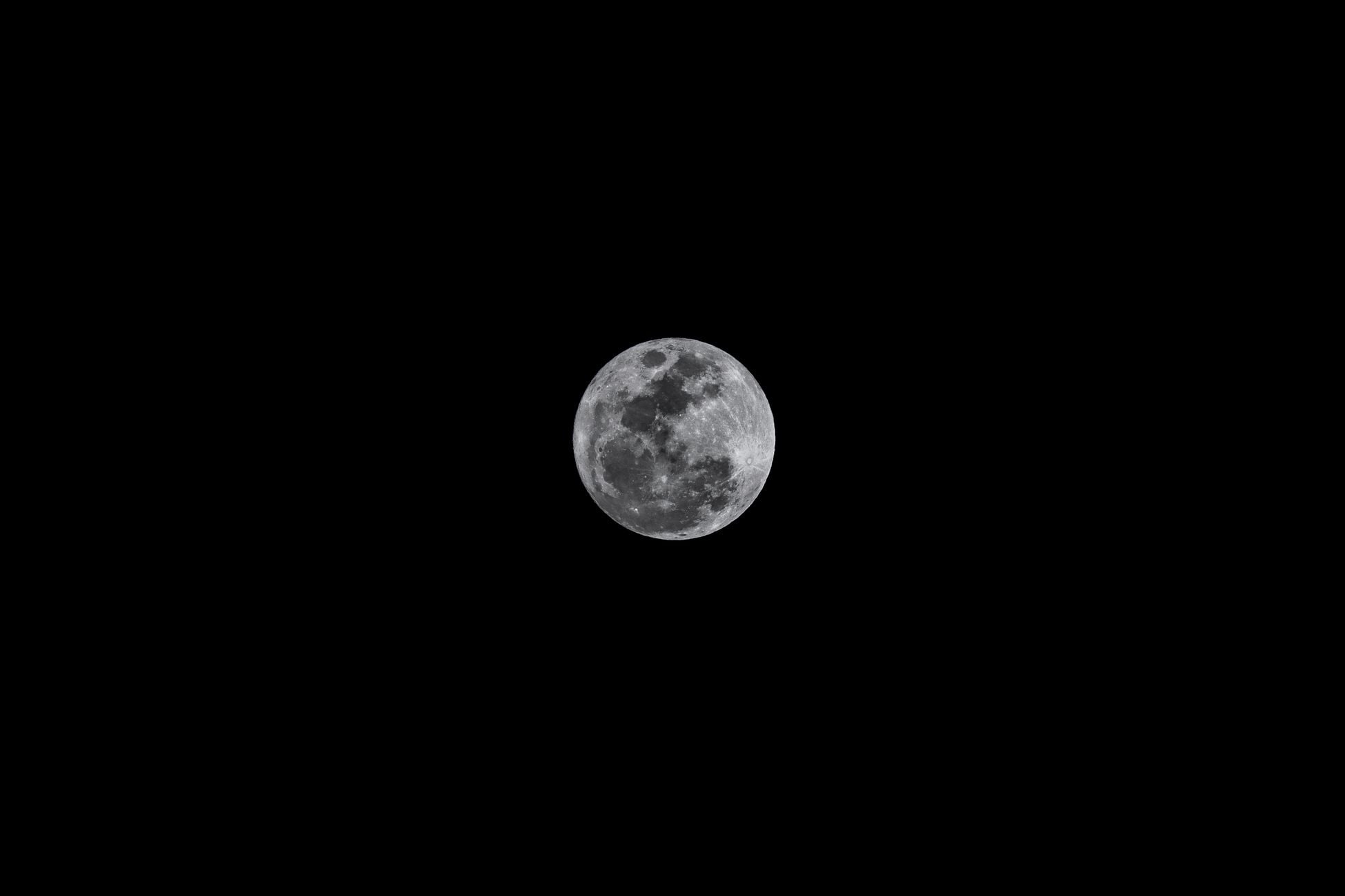 A clear and detailed photograph of the full moon in a black night sky.
