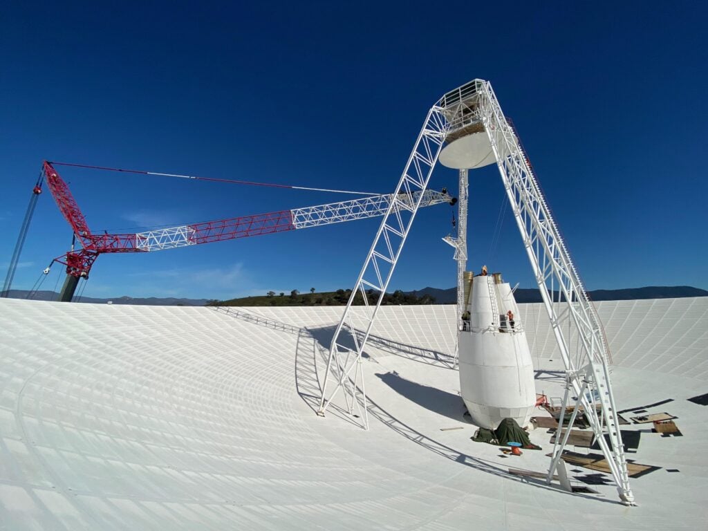 Photo: Spacedaily Workers and a crane inside the 70-metre DSS-43 antenna during upgrades in Canberra in 2020