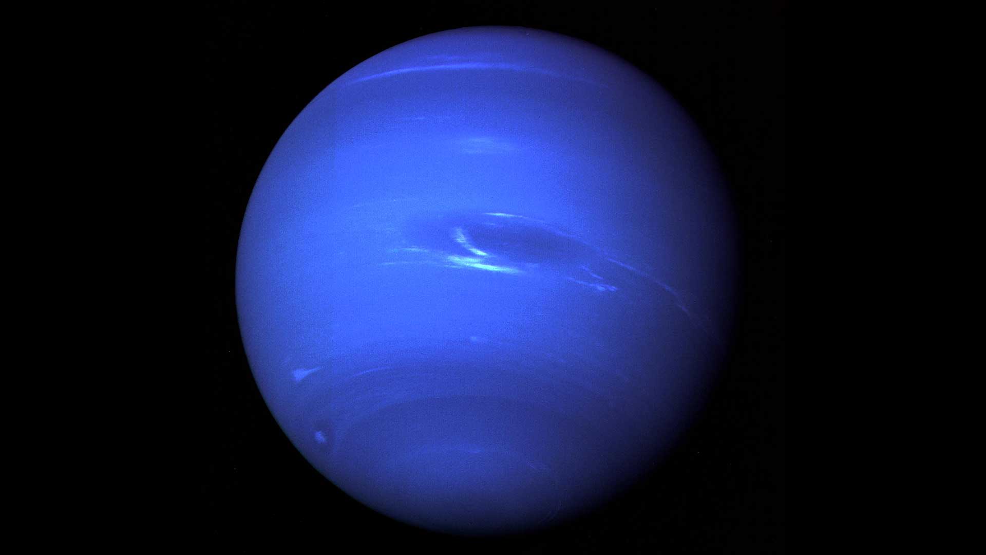 How does a planet 4.5 billion kilometres from the Sun, where daylight is roughly 900 times dimmer than on Earth, whip up the fastest winds in the entire solar system?