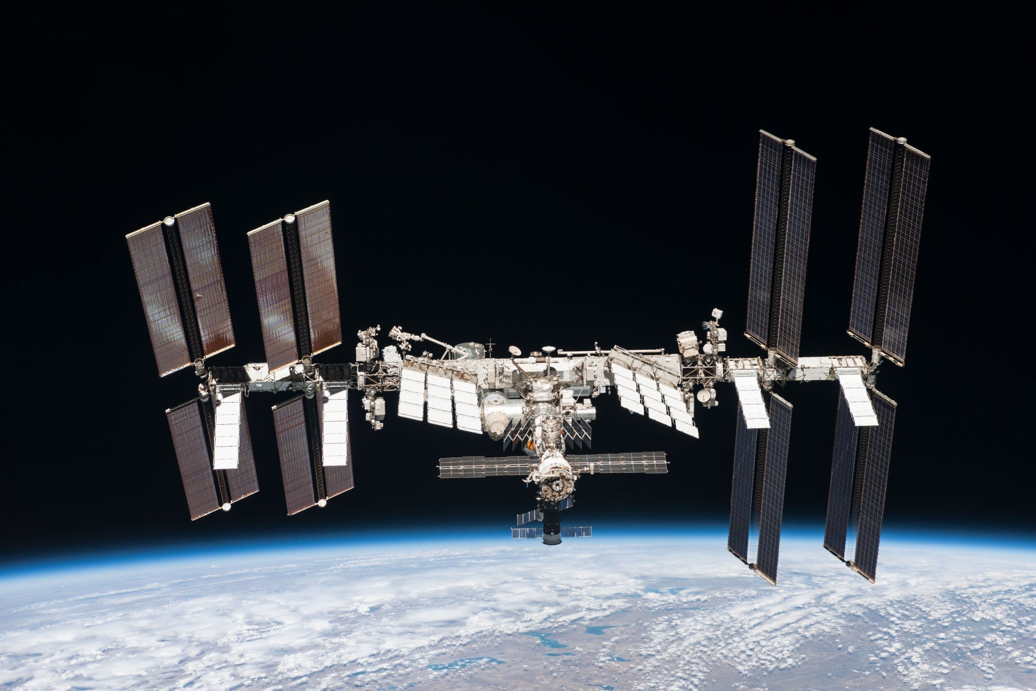 The International Space Station is not held up by rockets. It is falling constantly, in a precise arc that matches the curvature of Earth — a controlled fall that has continued without interruption since November 2000