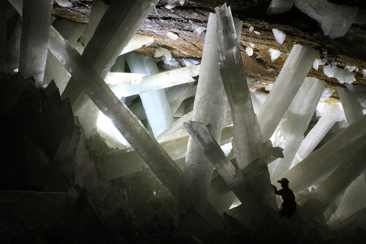 Giant gypsum crystals inside the Cave of the Crystals at Naica, Mexico, with a person standing among them for scale