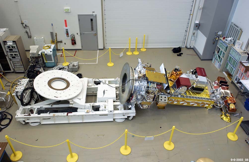 On September 6, 2003, the NASA-managed NOAA N-Prime weather satellite slipped from a turnover cart at Lockheed Martin’s Sunnyvale plant and fell about three feet to the floor after another project had removed the 24 bolts securing the cart’s adapter plate; the removal was never marked or communicated, and the handling team relied on old paperwork instead of physically checking the fixture.