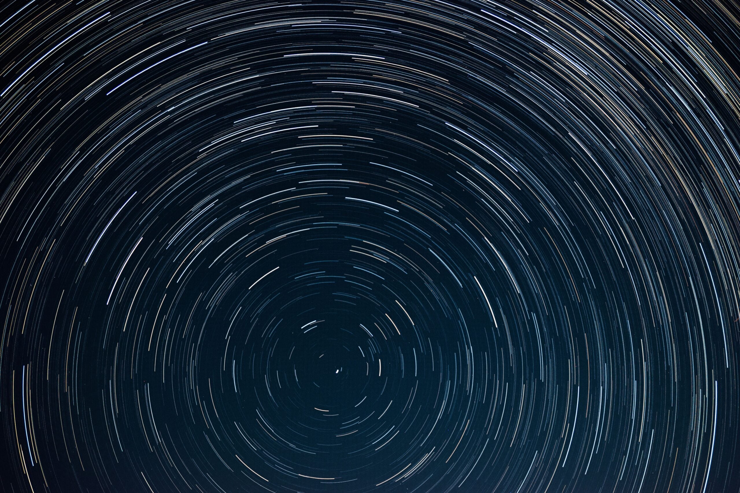 Circular star trails crossing a dark night sky in a long-exposure photograph