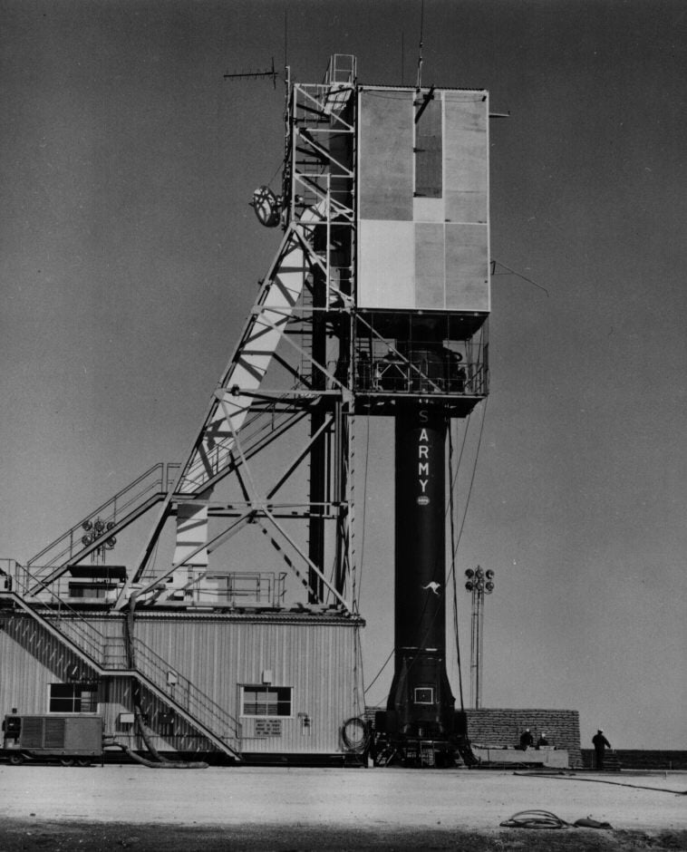 A Redstone-Sparta rocket beside its launch gantry at Woomera, South Australia.